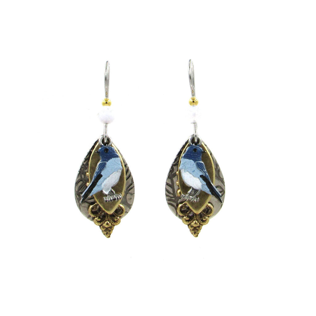 Teardrop-shaped earrings featuring a bluebird on a gold oval over a patterned silver background.