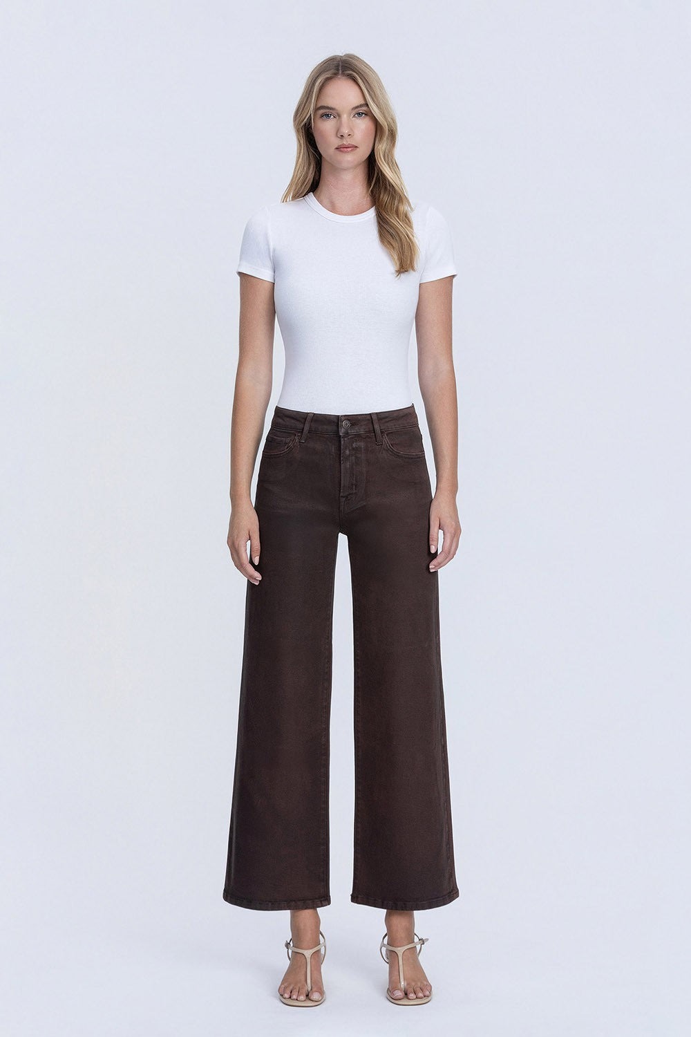 Woman wearing Kitty High Rise Coated Wide Leg Jeans in dark brown with a white t-shirt.