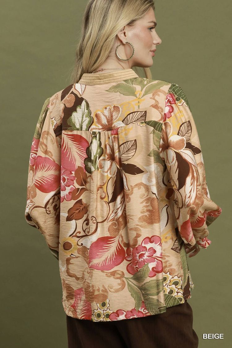 Back view of a woman wearing a beige Mia Floral Print V-Neck Blouse with long puff sleeves.