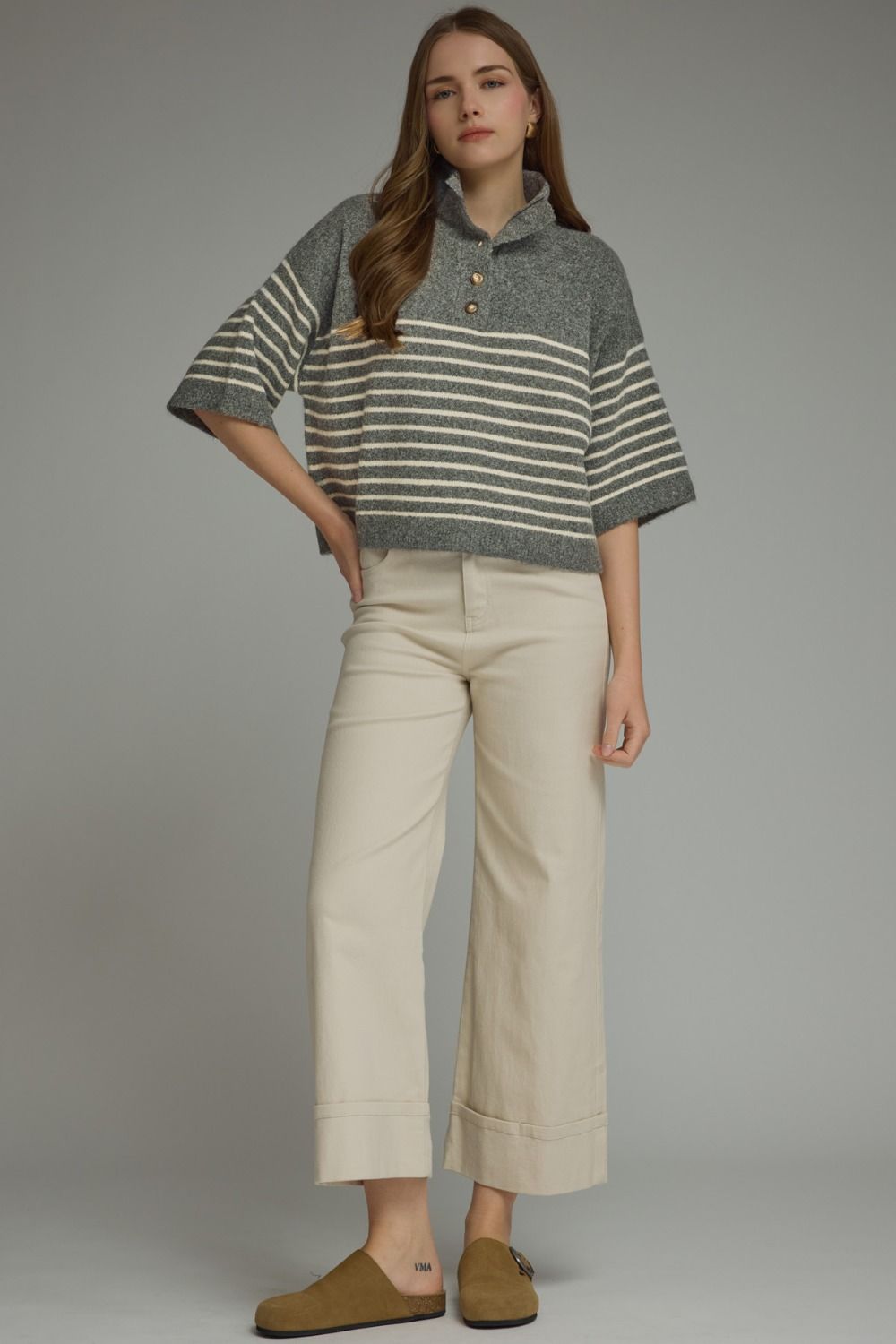 Woman wearing a grey and white Charlene Stripe Short Sleeve Knit Top with a mock neck and buttons.