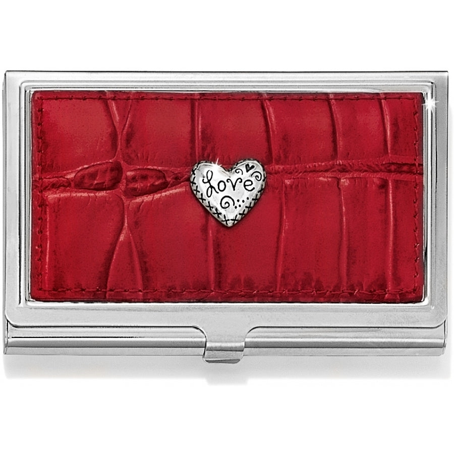 Red crocodile-embossed leather card case with a silver heart charm featuring the word 'Love'.