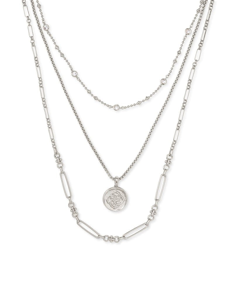 Triple strand necklace in gold featuring a medallion coin pendant on three metallic chains with lobster claw closure.