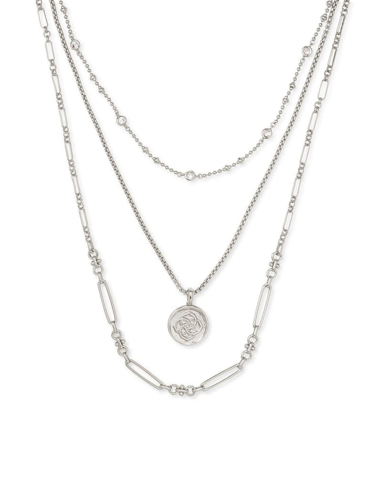 Triple strand necklace in gold featuring a medallion coin pendant on three metallic chains with lobster claw closure.