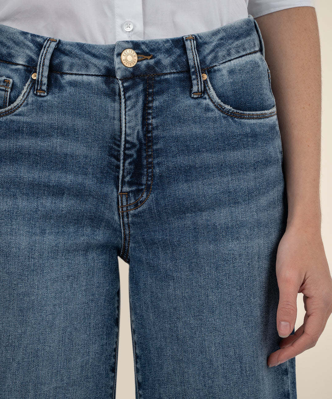Woman wearing Meg high-rise wide-leg jeans in Family wash with front pockets and raw hem.