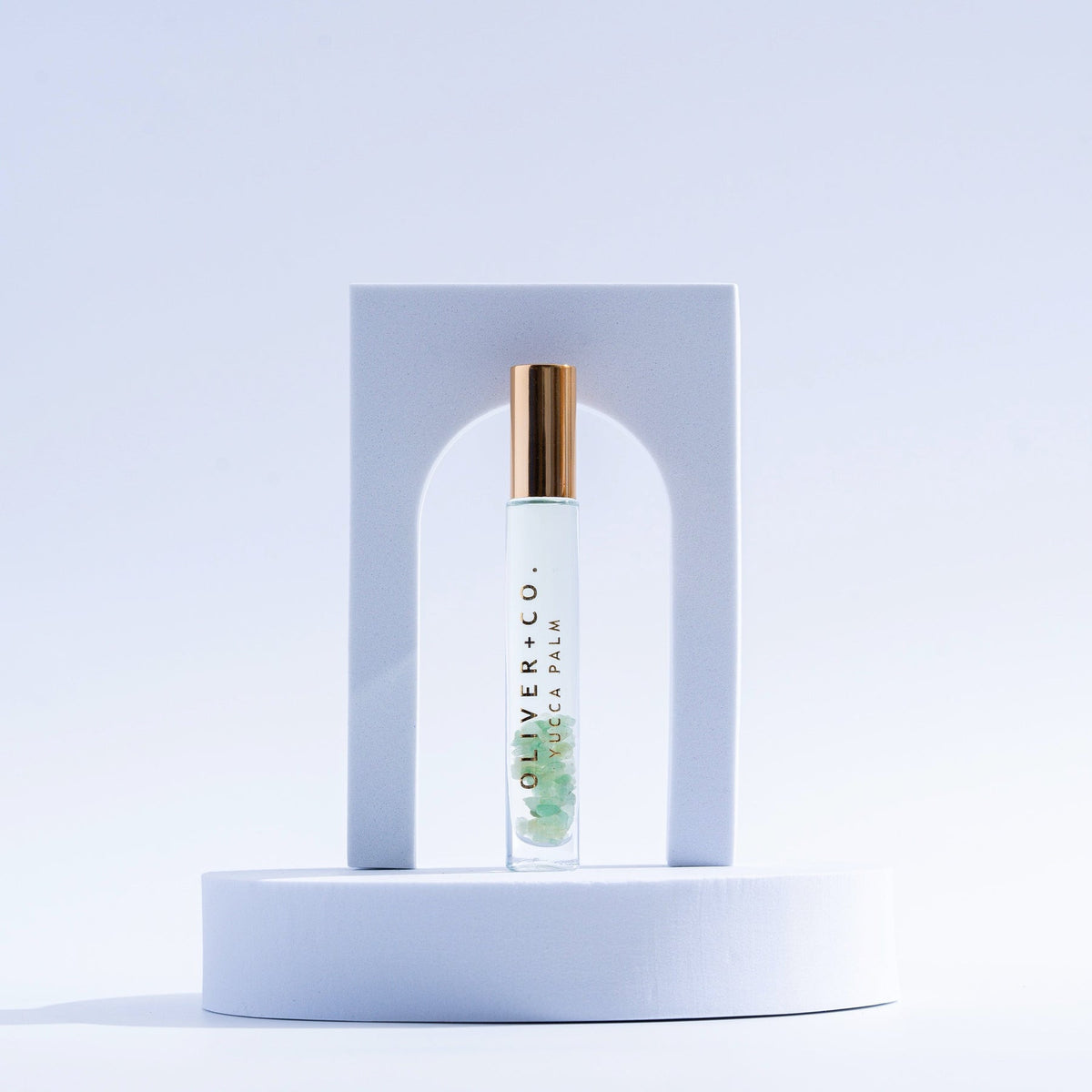 Oliver + Co. Yucca Palm Bougie Stick roll-on perfume with green crystals inside a glass bottle.