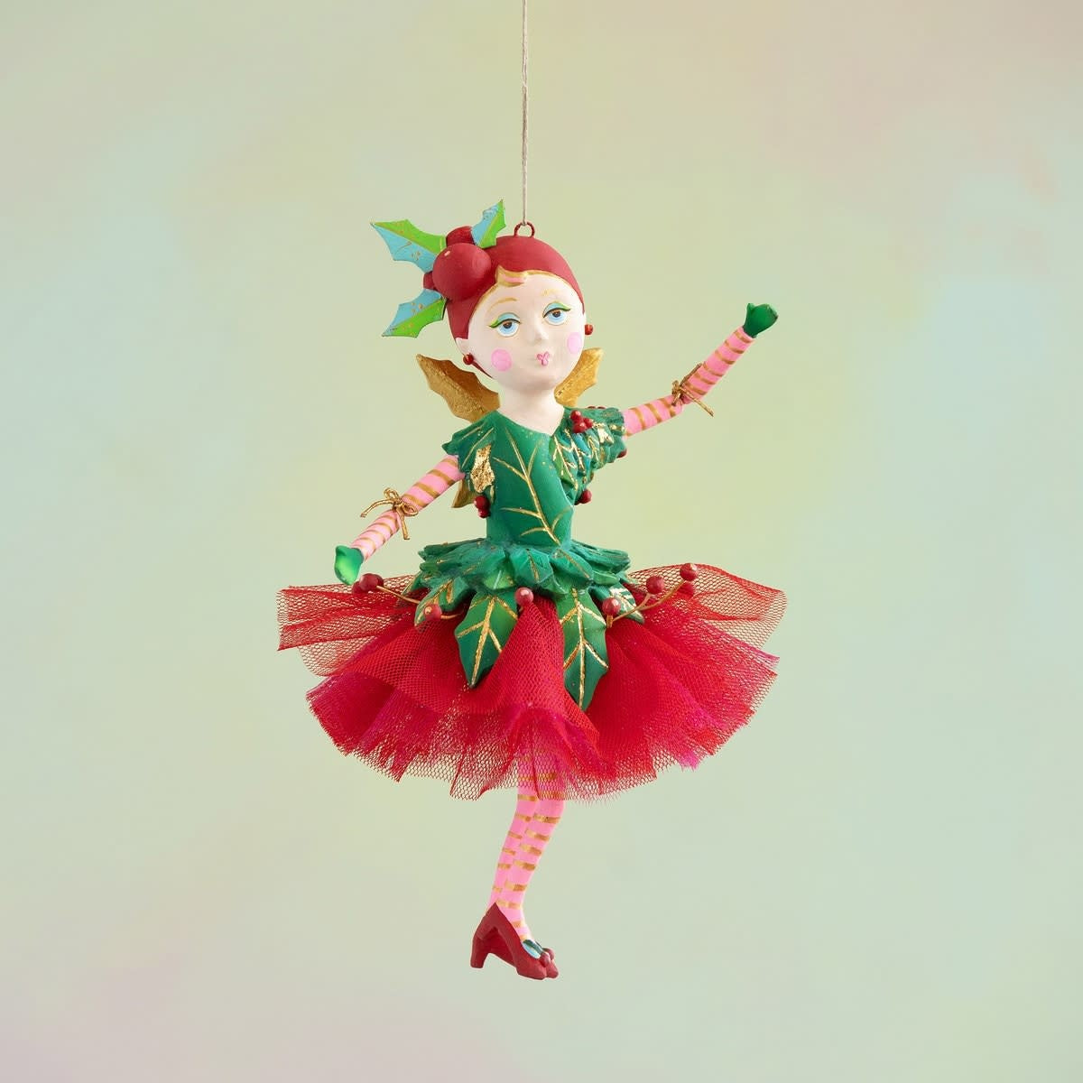 Resin ornament figurine of a woman in a red and green holly-patterned midi dress standing 17.5 inches tall.