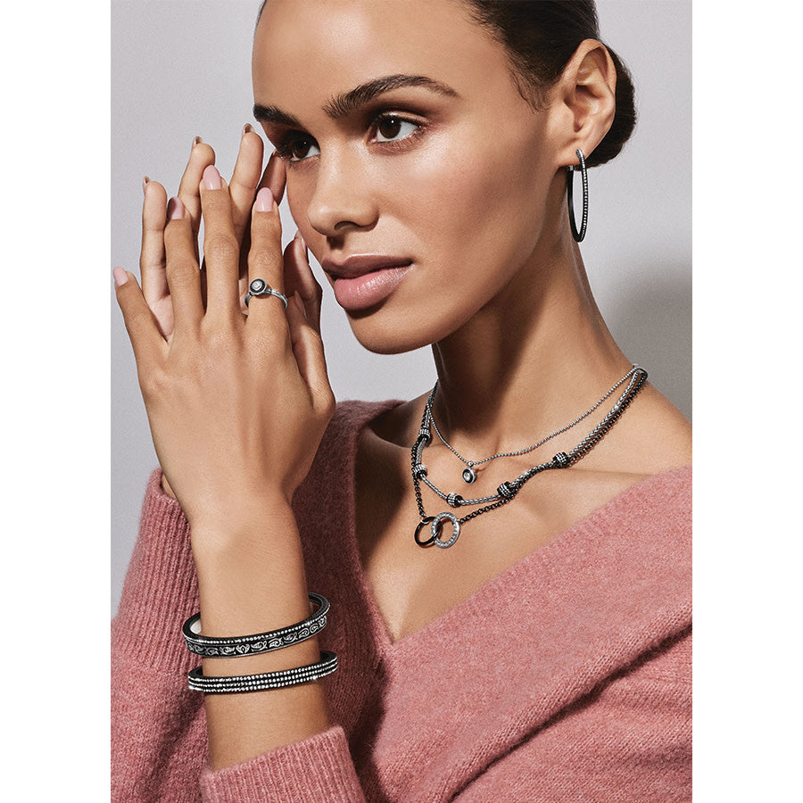 Black lacquer hoop earrings with fine crystal pave detailing on a post lever back.