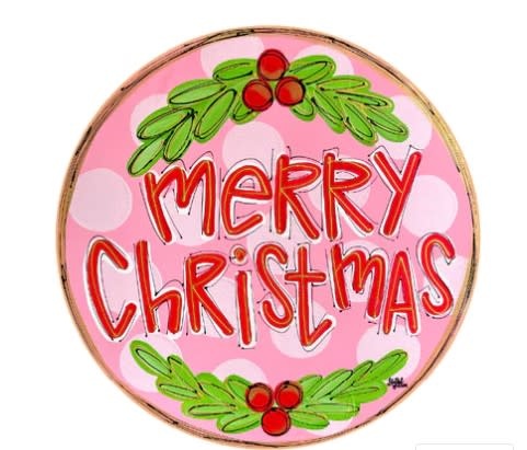 Wooden door hanger with pink polka dot background featuring Merry Christmas text in white script.