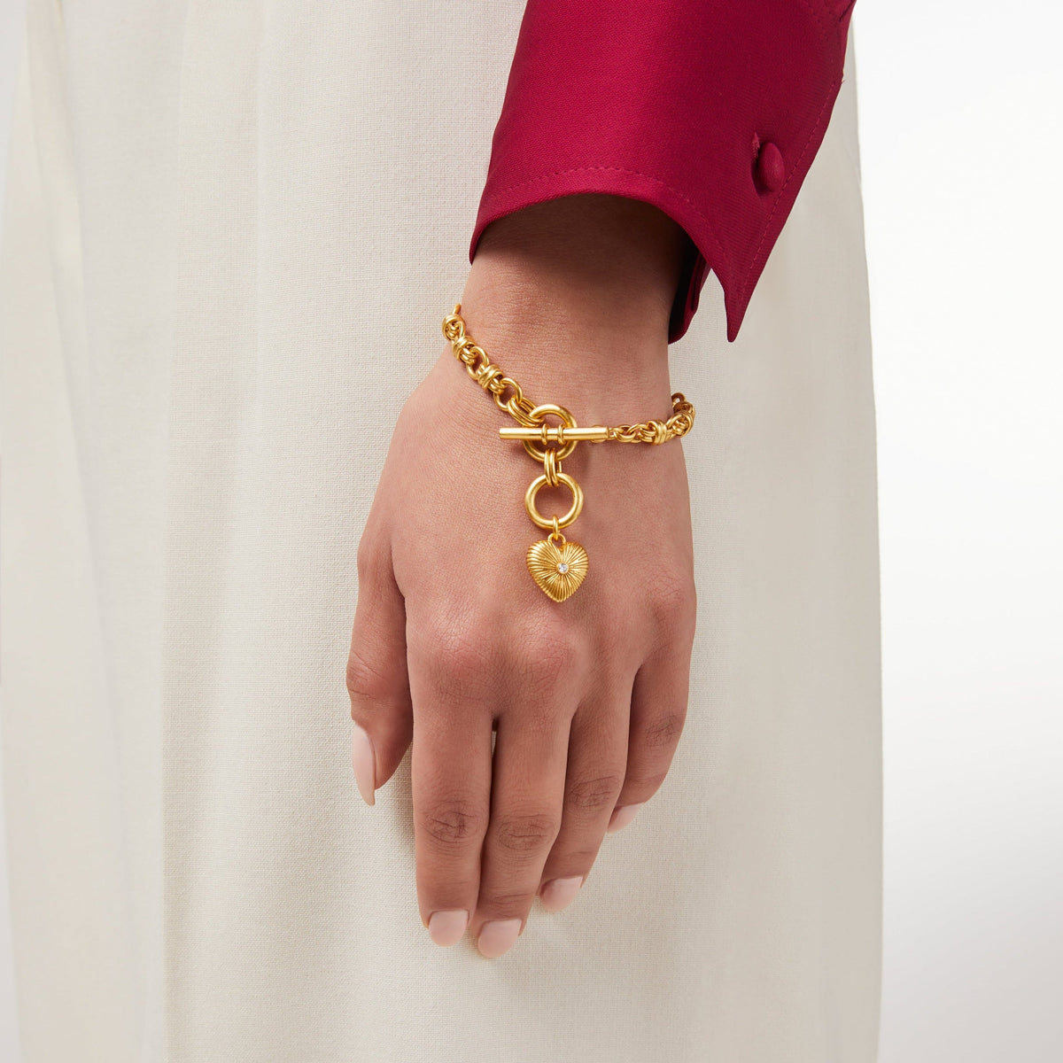 Gold heart-shaped bracelet with cubic zirconia stones on a gold chain.