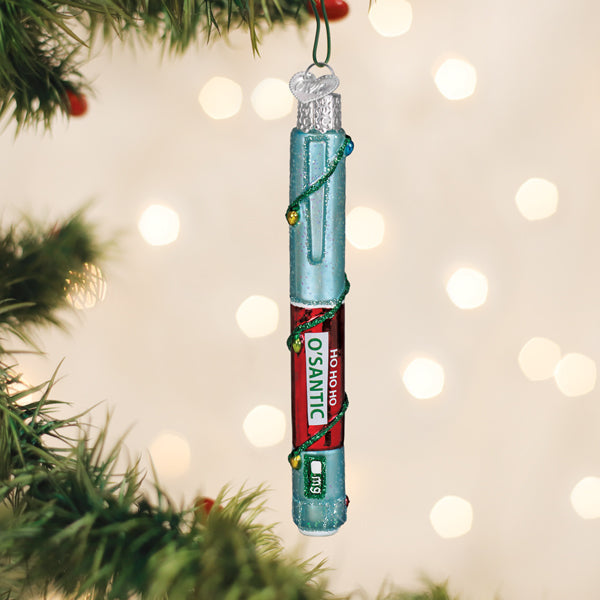 Glass Christmas ornament shaped like a medical injector pen with Ho Ho Ho O'santic label.