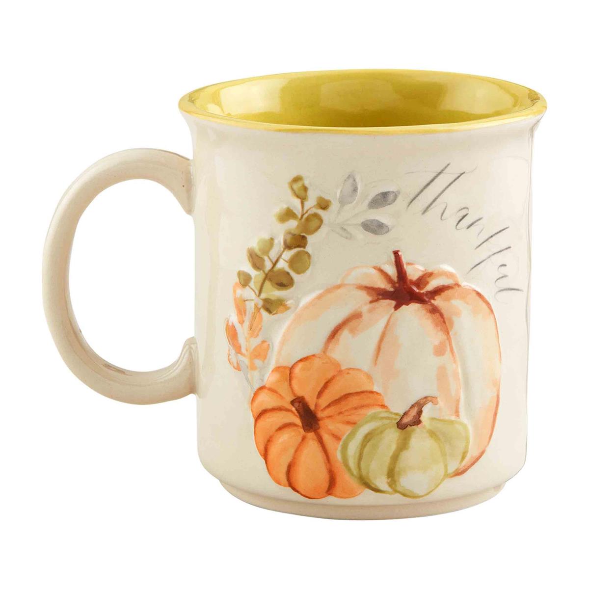 Cream stoneware mug with yellow interior, featuring pumpkins and the word "thankful".