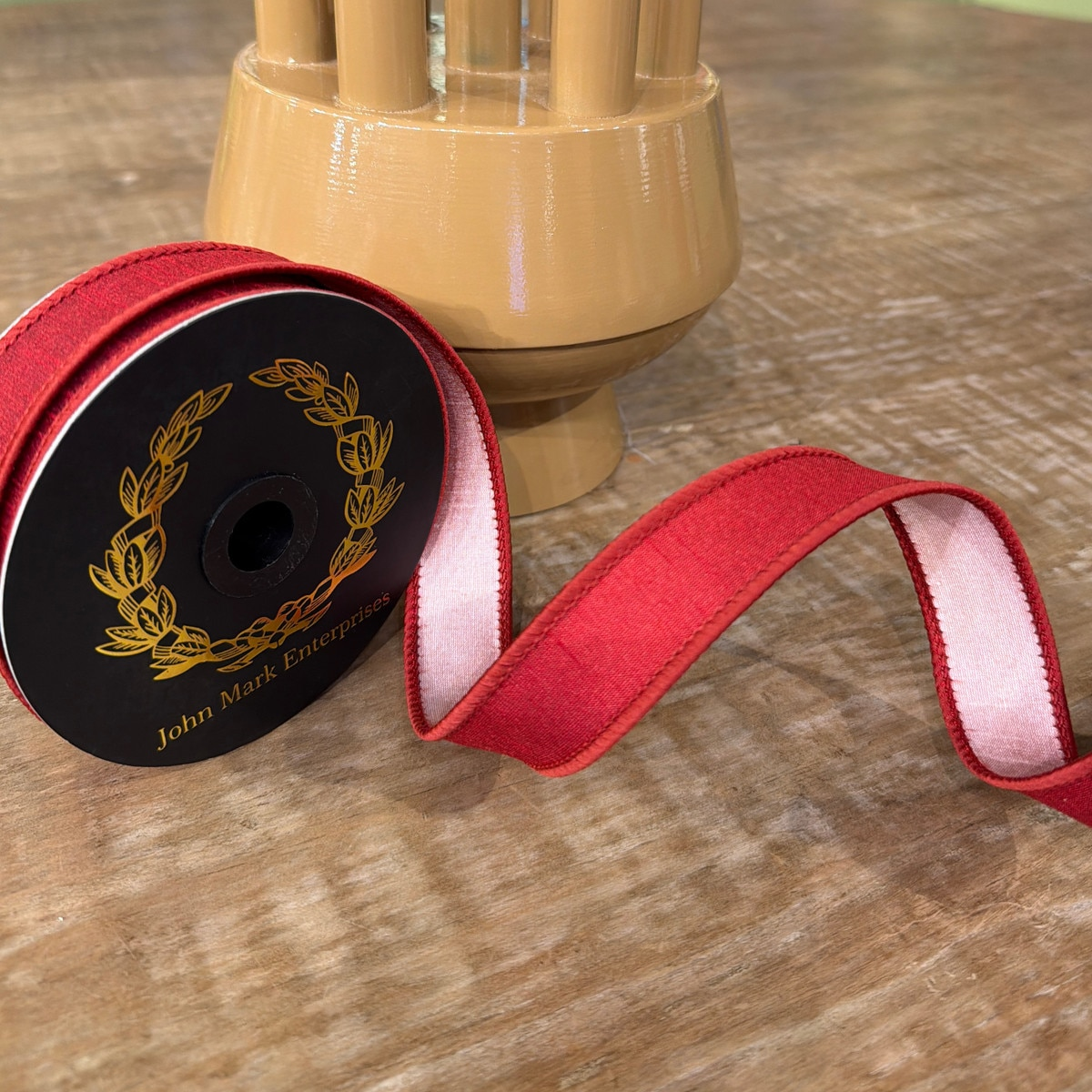 Spool of 1x10yd Dupion Double Fused Currant Ribbon with a red exterior and light pink interior.