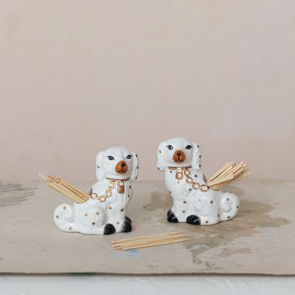 Ceramic Staffordshire dog-shaped toothpick holder in off-white with black silhouette detailing.