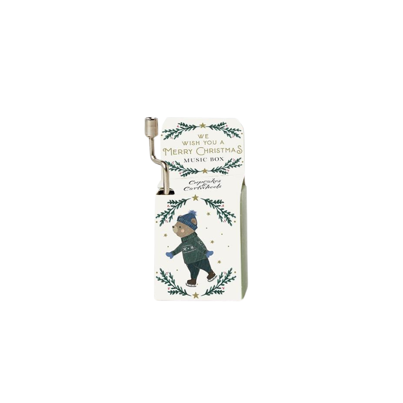 Hand-cranked Christmas music box featuring a bear on ice skates and festive holiday illustrations.