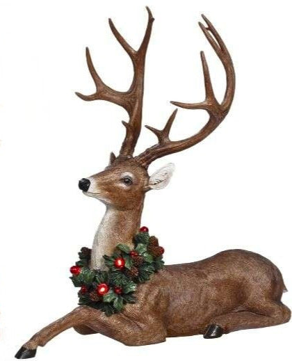 21-inch reclining reindeer figurine with large antlers and a festive holiday wreath around its neck.