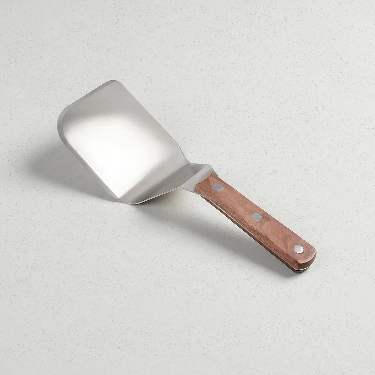 Full tang stainless steel spatula with a walnut handle featuring an extra wide blade.