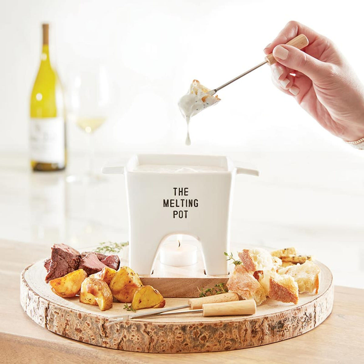 Ceramic mini fondue pot with wooden handle holding two metal skewers