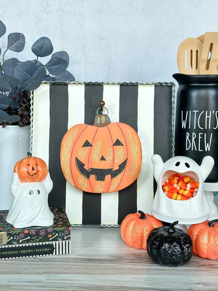 Mini Jack O'Lantern charm with carved pumpkin face on a hanging metal loop