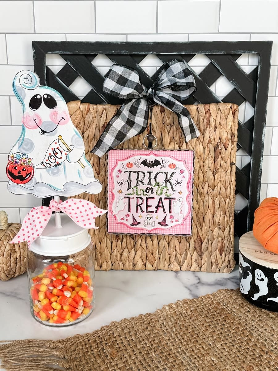 Mini pink Halloween print featuring a trick-or-treat character on white paper.