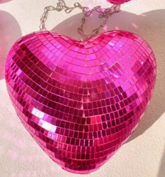 Heart-shaped disco ball with rainbow glitter finish on a black stand