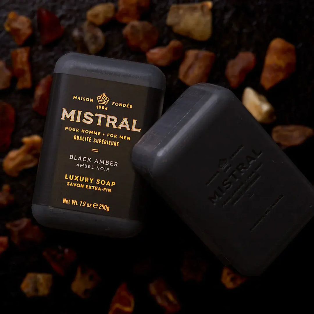 Triple-milled black bar soap with amber hue featuring citrus and wood scent notes.