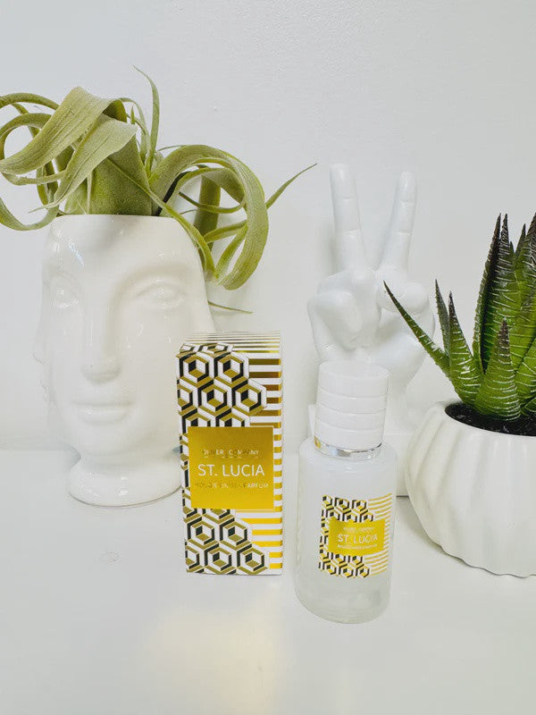 St. Lucia Fragrance Mist bottle and patterned box next to a face planter and peace sign sculpture.