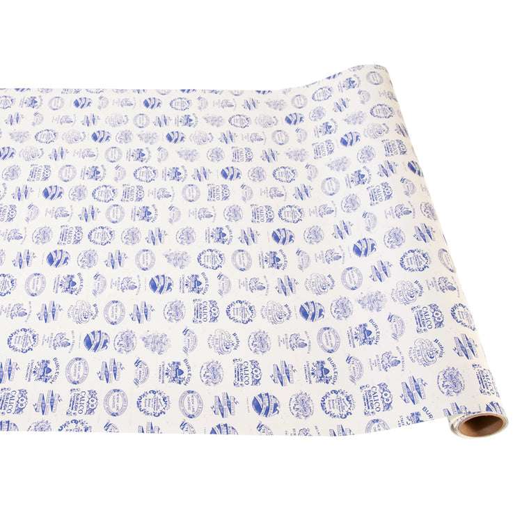 White wrapping paper with a repeating blue pattern of oval-shaped stamps and floral designs.