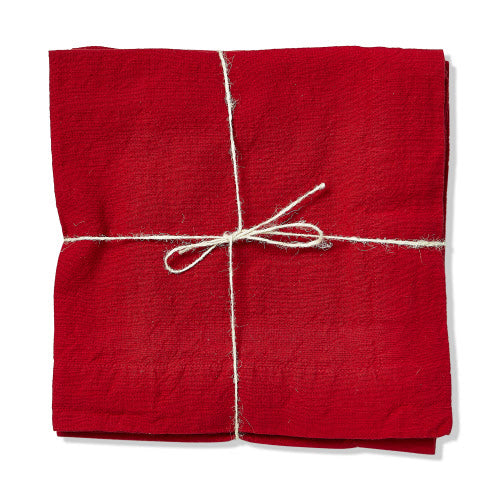 Set of red slub fabric napkins folded and tied with a simple white twine bow.