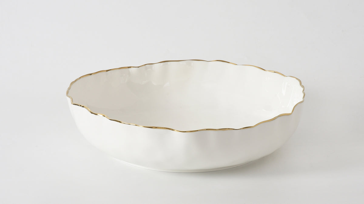 Extra large shallow white porcelain bowl with a wavy gold-finished rim.