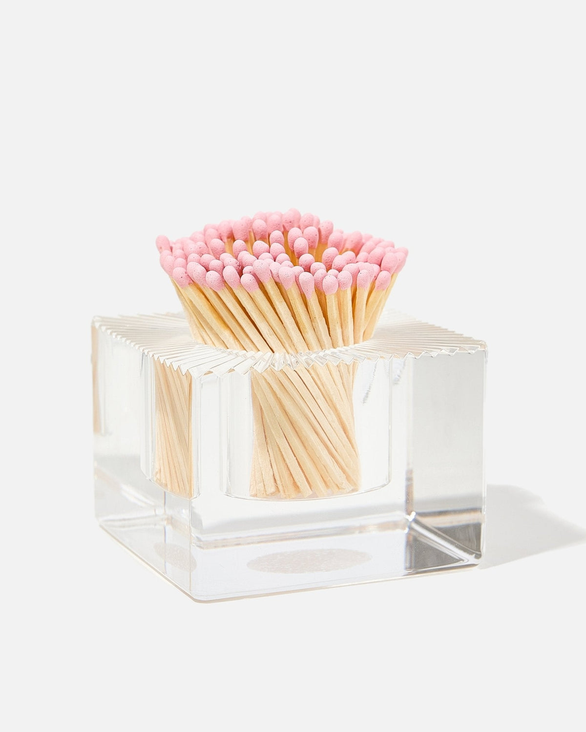 Clear glass square match striker filled with pink-tipped wooden matches.