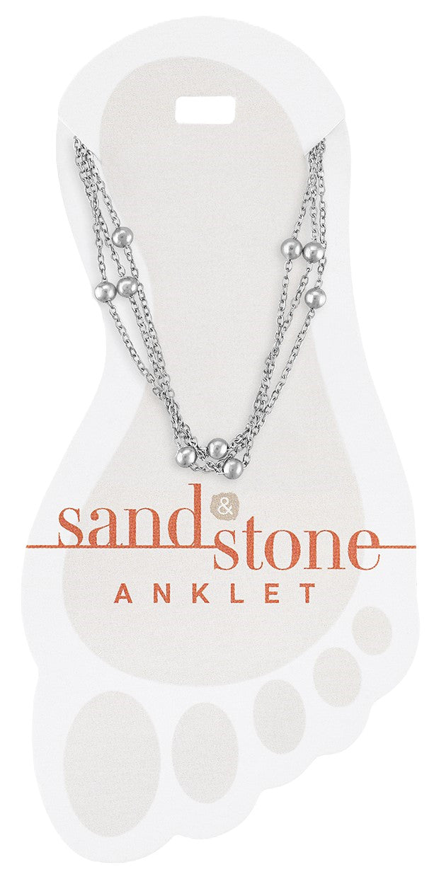 Silver multi-strand anklet with small round beads on a foot-shaped display card.