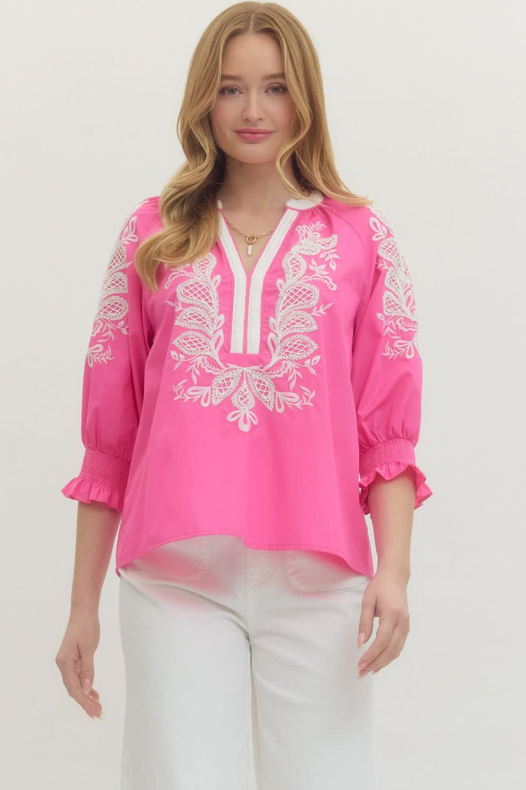 Woman wearing a pink Madelyn top with white embroidery, split V-neck, and elasticated 3/4 sleeves.