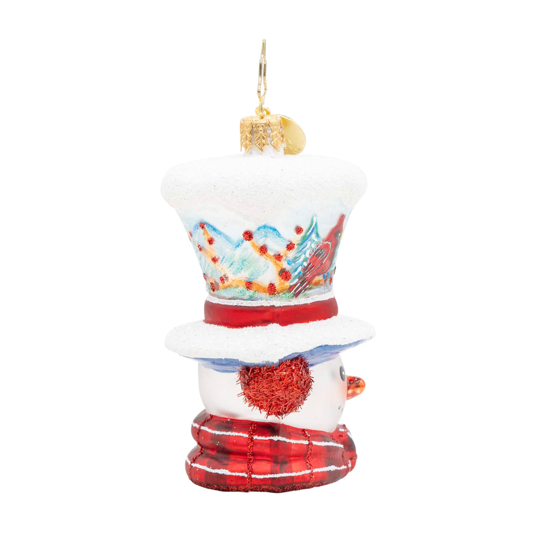 Snowman ornament with a hand-painted winter scene on its top hat and a red plaid scarf.