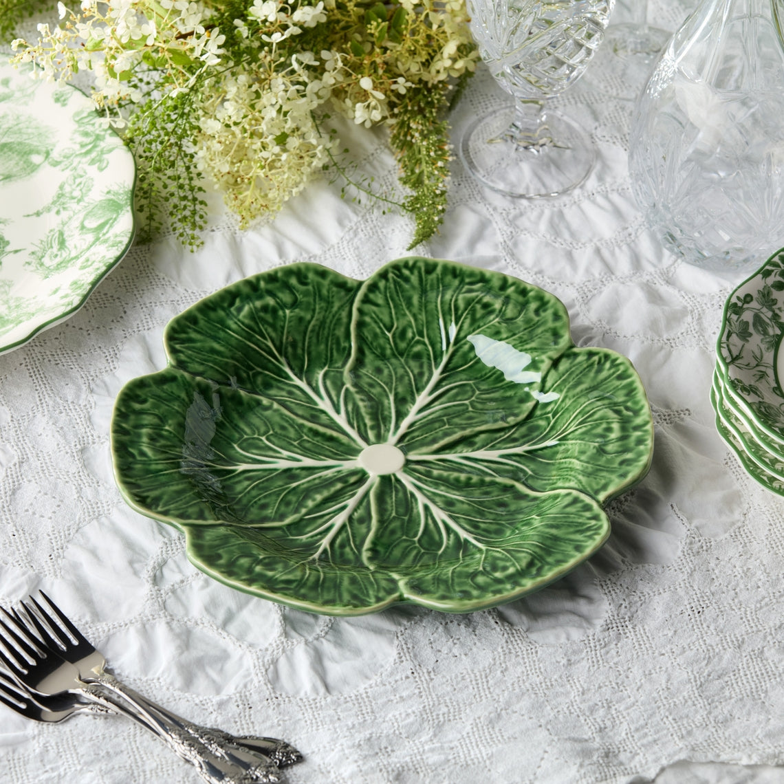 Green sculptural cabbage dinner plate with raised edges and white veining