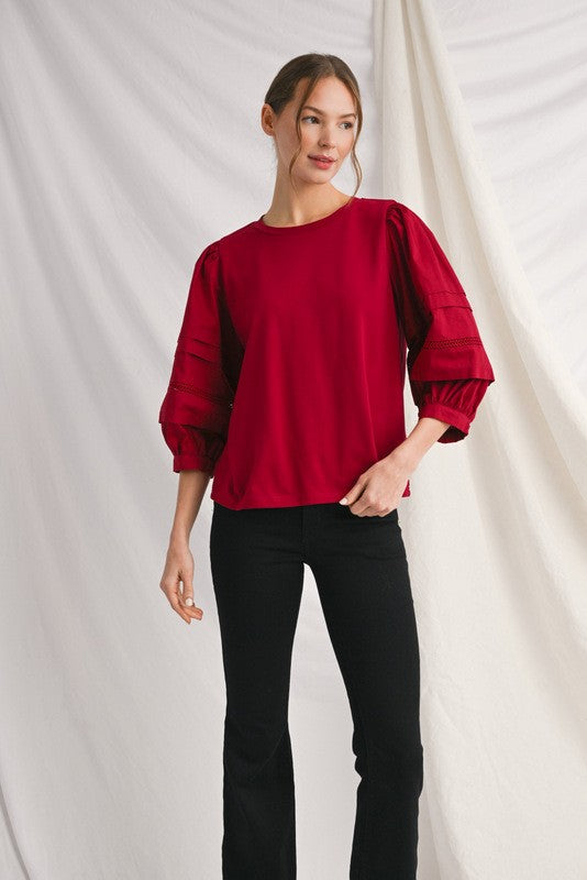 Alice solid top with ladder lace trim at neckline and button closure cuffs.