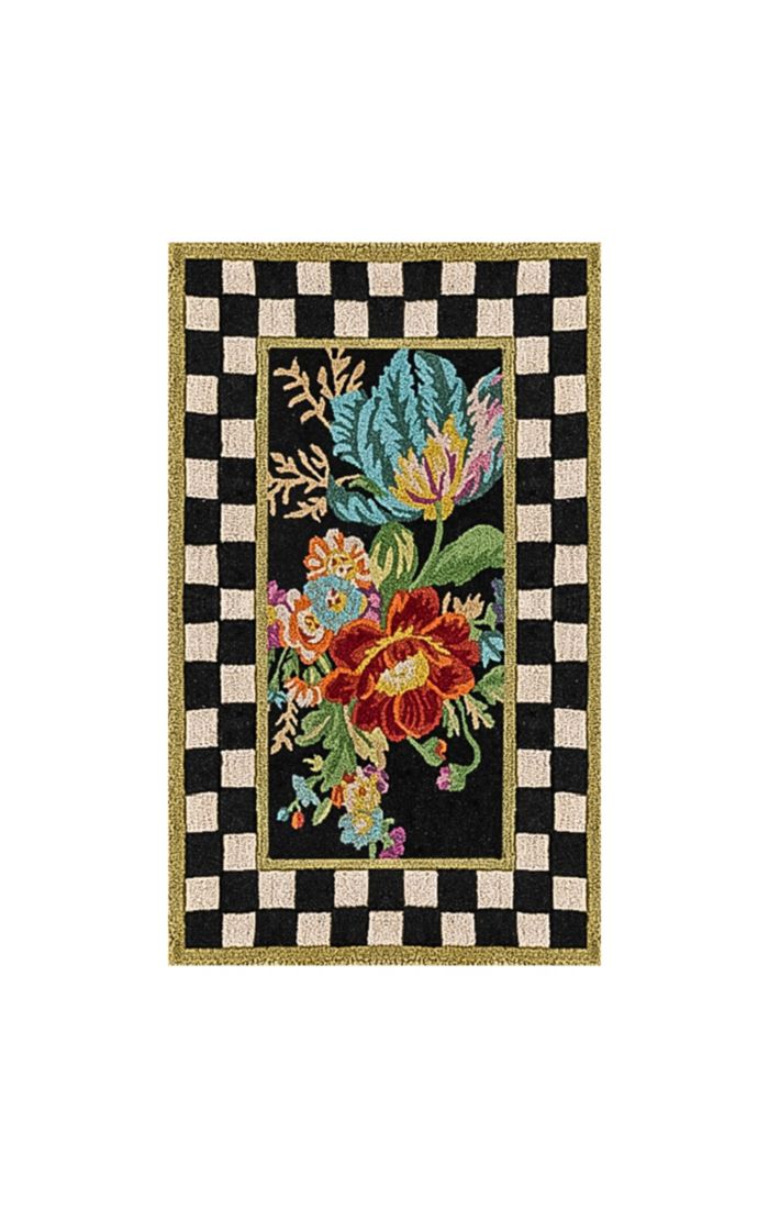 Rectangular washable rug with a black and white checkered border and a colorful floral center.