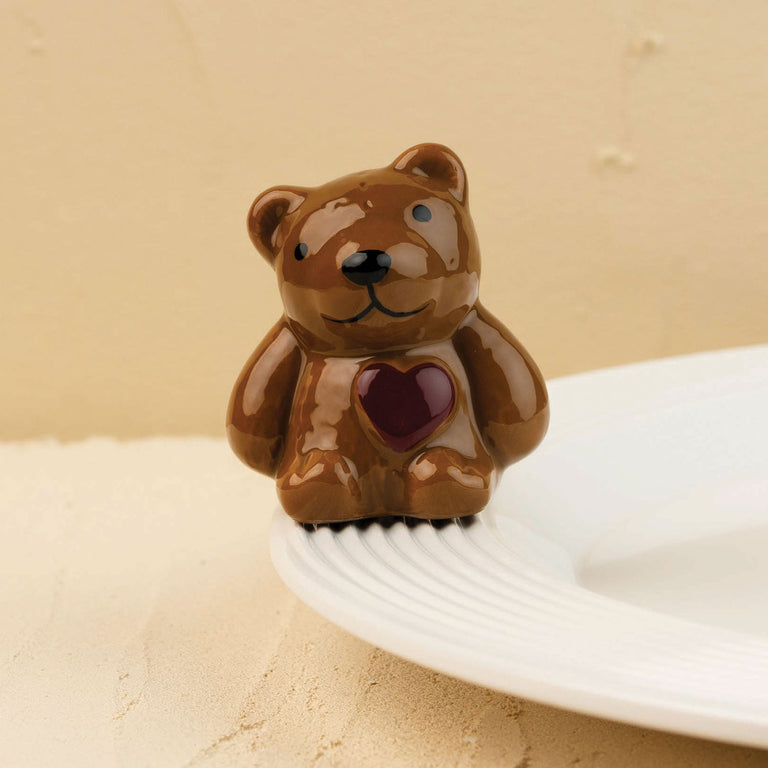 Hand-painted brown ceramic teddy bear mini with a dark red heart on its chest, sitting on a plate.