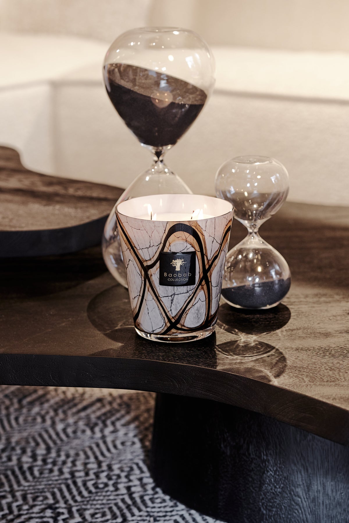 Baobab Collection Marble Stones candle with a marble-patterned glass on a dark wood table.