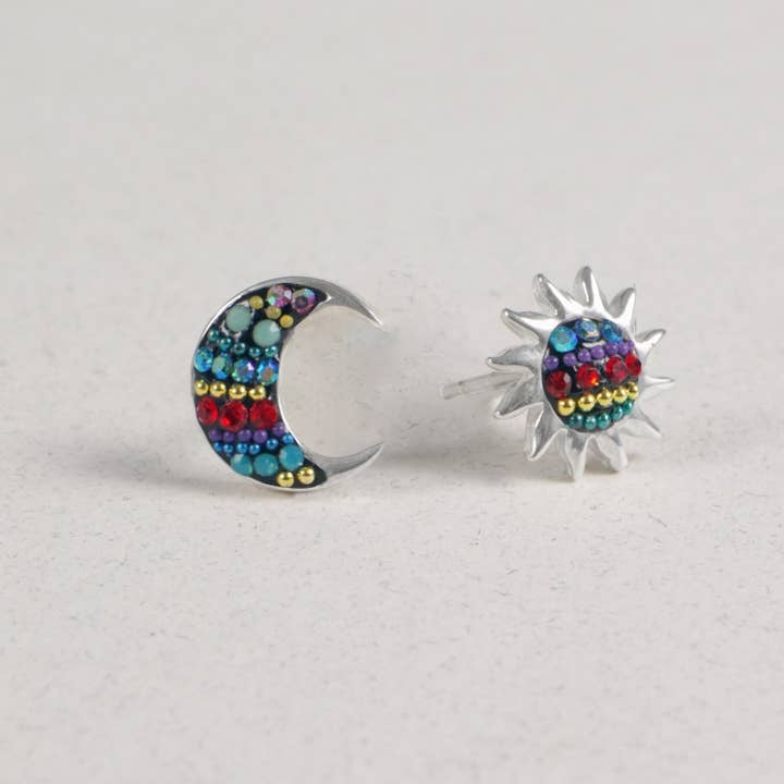 Sterling silver stud earrings featuring a moon shape surrounded by sun rays set with Austrian crystals.