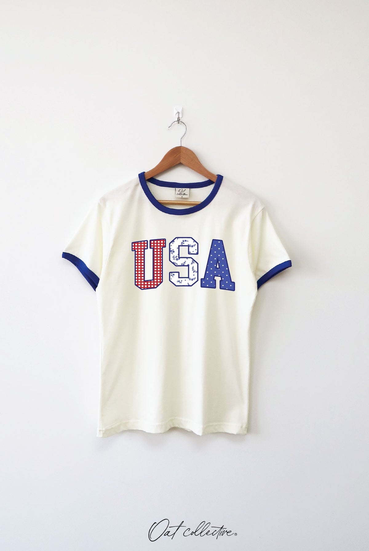 Off-white ringer tee with blue trim and 'USA' graphic in red, white, and blue patterns.