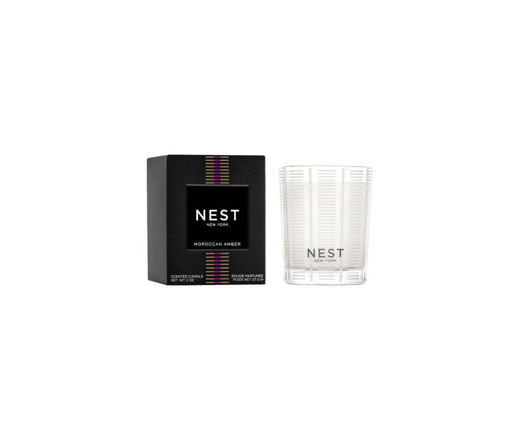 Moroccan amber Nest votive candle in a clear glass holder with smooth cylindrical silhouette.
