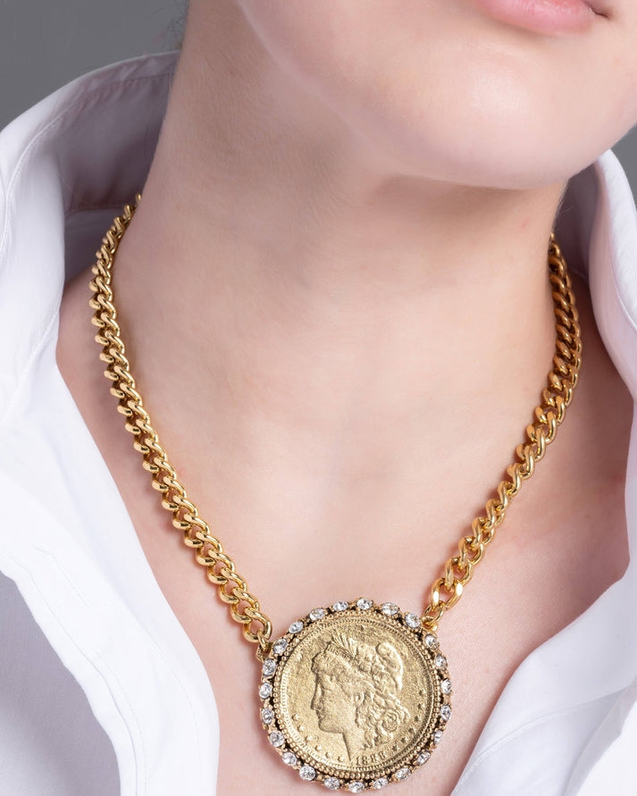 Lucia gold curb chain necklace with a vintage coin medallion pendant encircled by crystals.