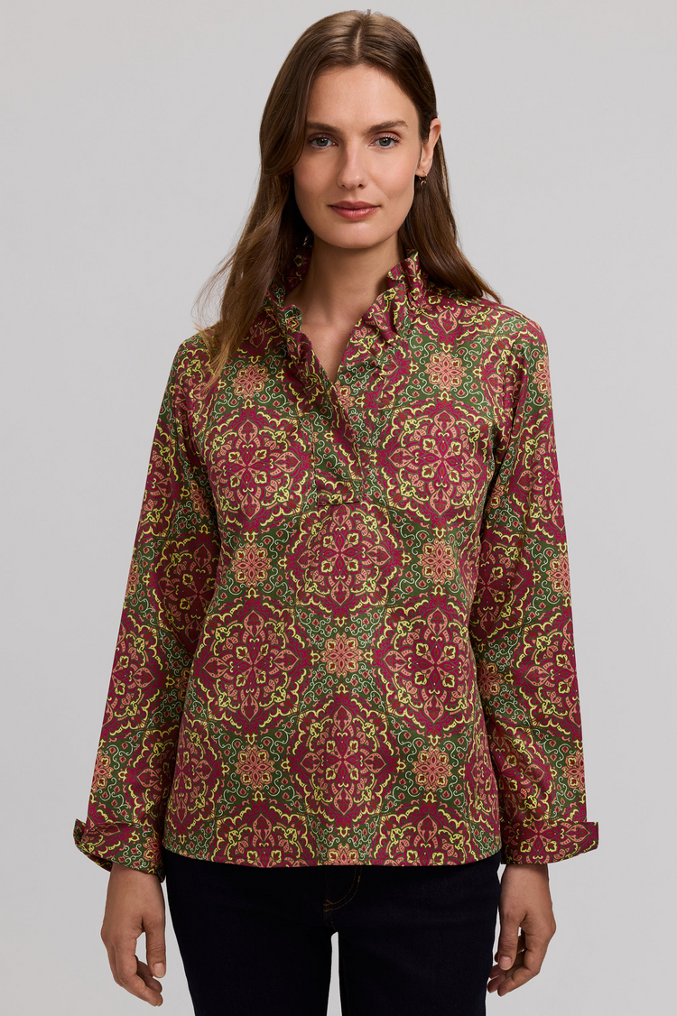 Woman wearing a Tammy Fall Medallion long sleeve popover shirt with a ruffled neckline.