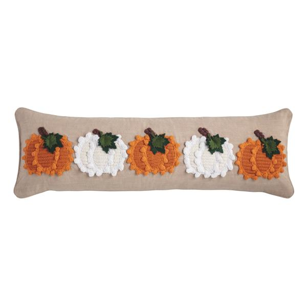 Long beige lumbar pillow featuring five knit pumpkins in alternating orange and white colors.