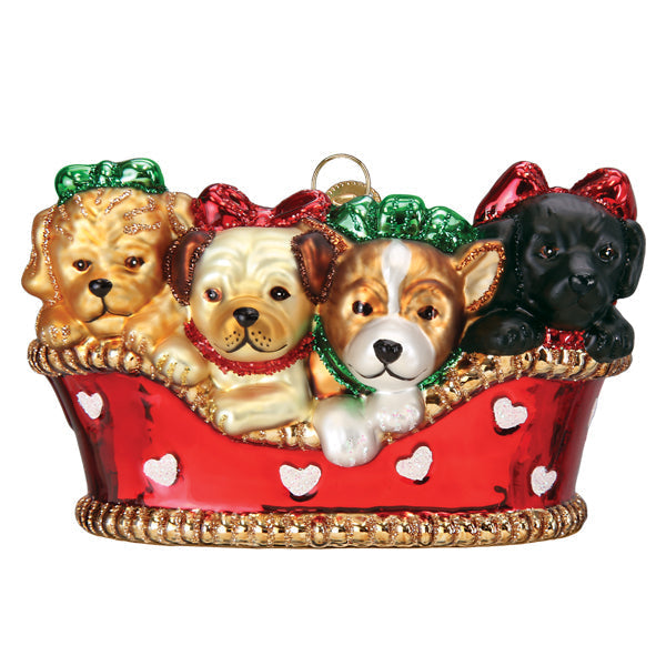 Glass Christmas ornament featuring four puppies in a red basket decorated with white hearts.