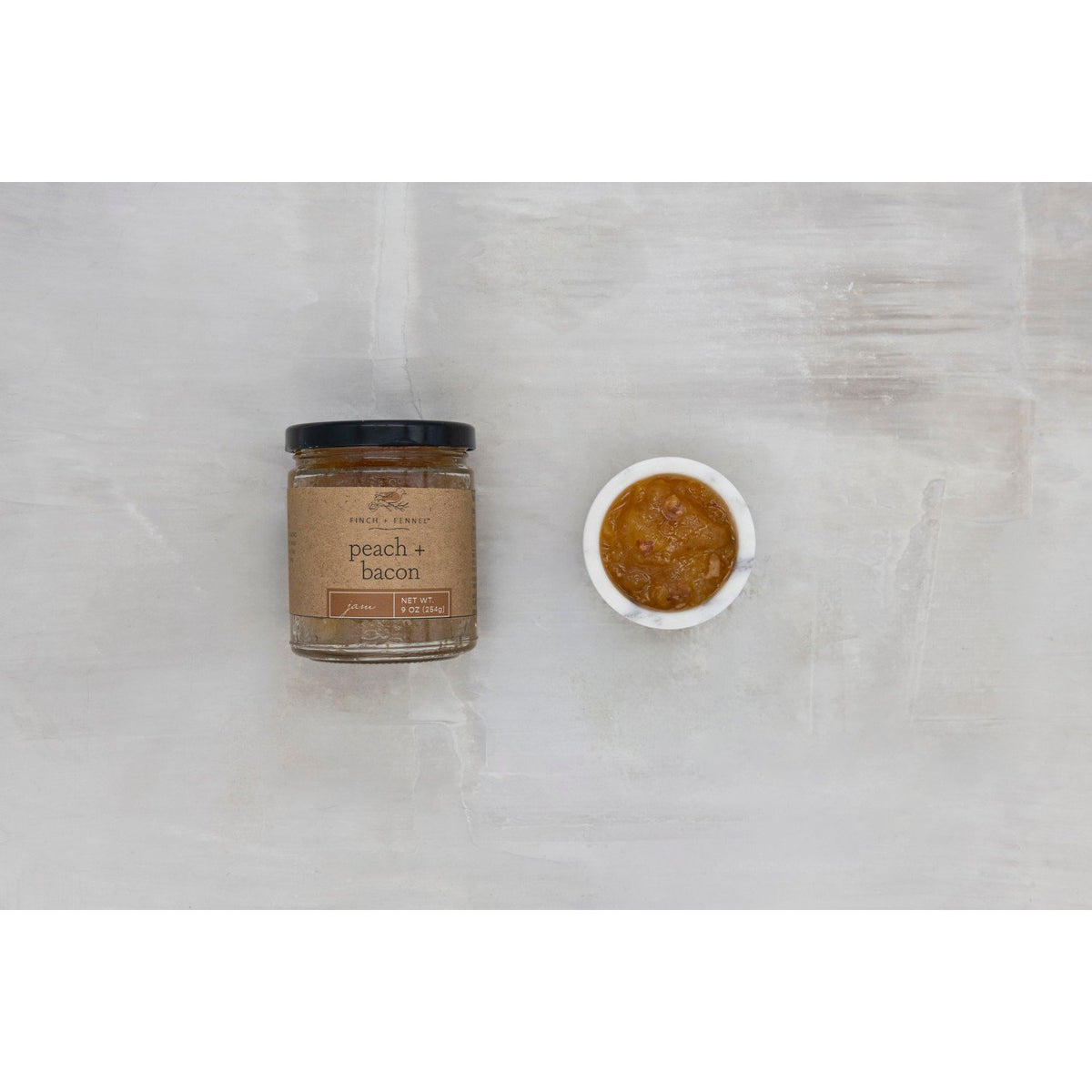 9 oz jar of peach and bacon jam with a vibrant orange spread visible through clear glass.