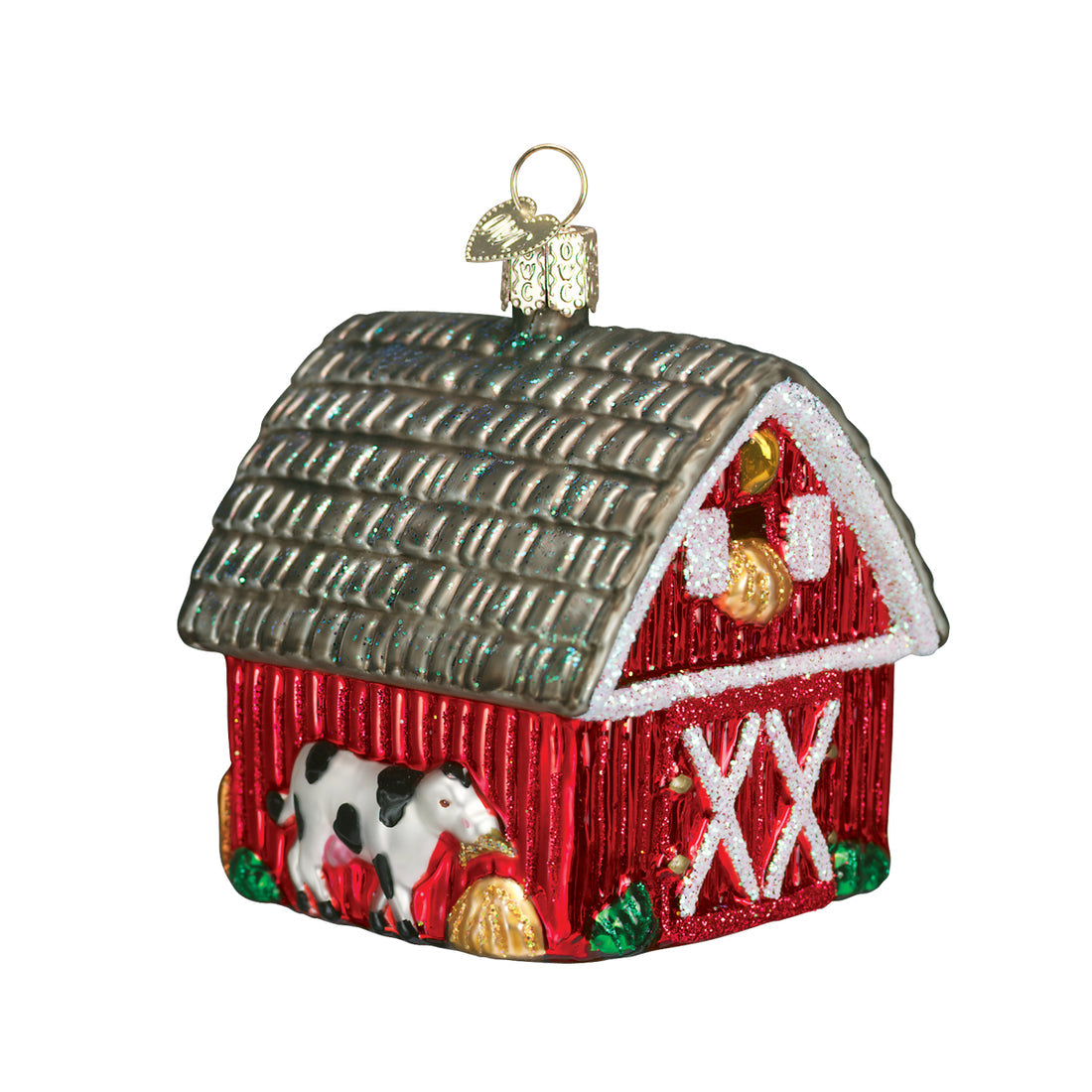 Red glass barn Christmas ornament with a black and white cow, hay bale, and glittery roof.