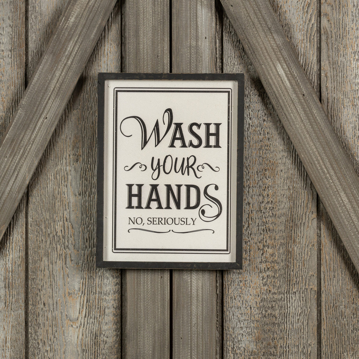 Framed wood sign with 'Wash Your Hands, No, Seriously' text on a rustic barn door background.