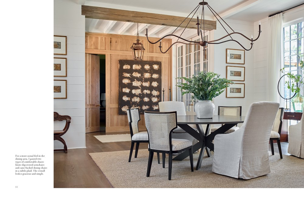 Interior design book spread showing a dining room with a round table, cane chairs, and chandelier.
