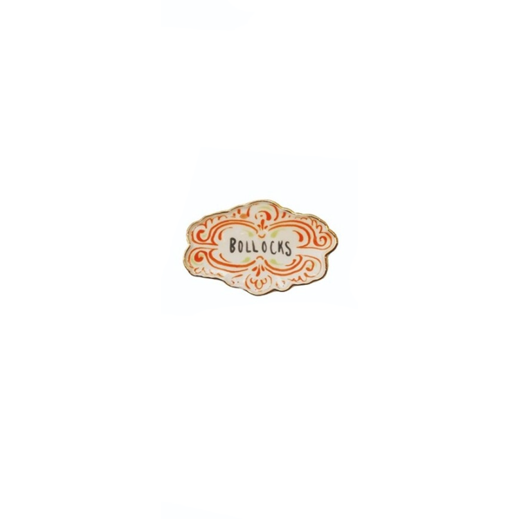 Decorative stoneware magnet with orange scrollwork and the word BOLLOCKS in the center.